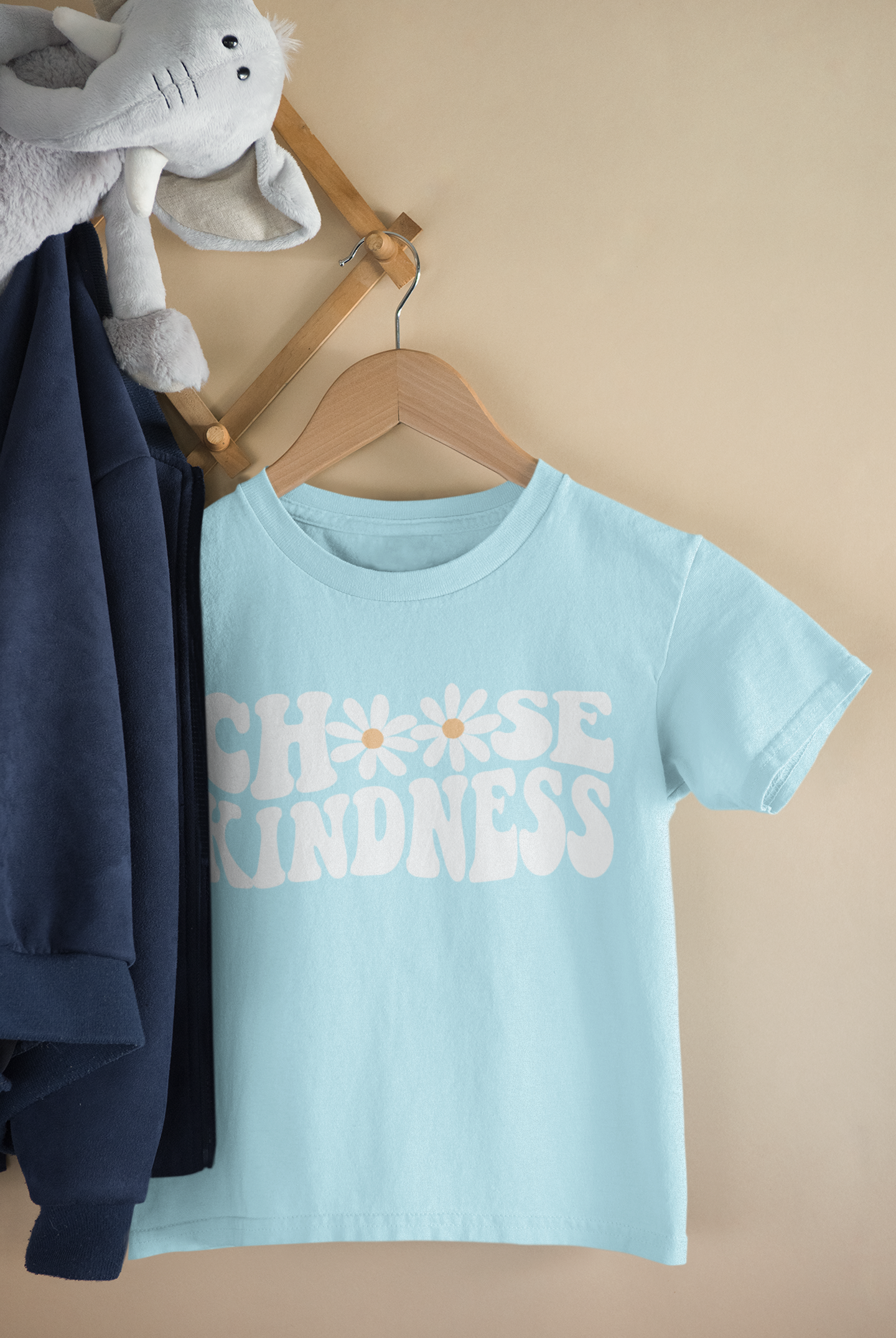 A light blue kids t-shirt on a hanger that says "Choose Kindness" blue t-shirt where the letter O is replaced with flowers