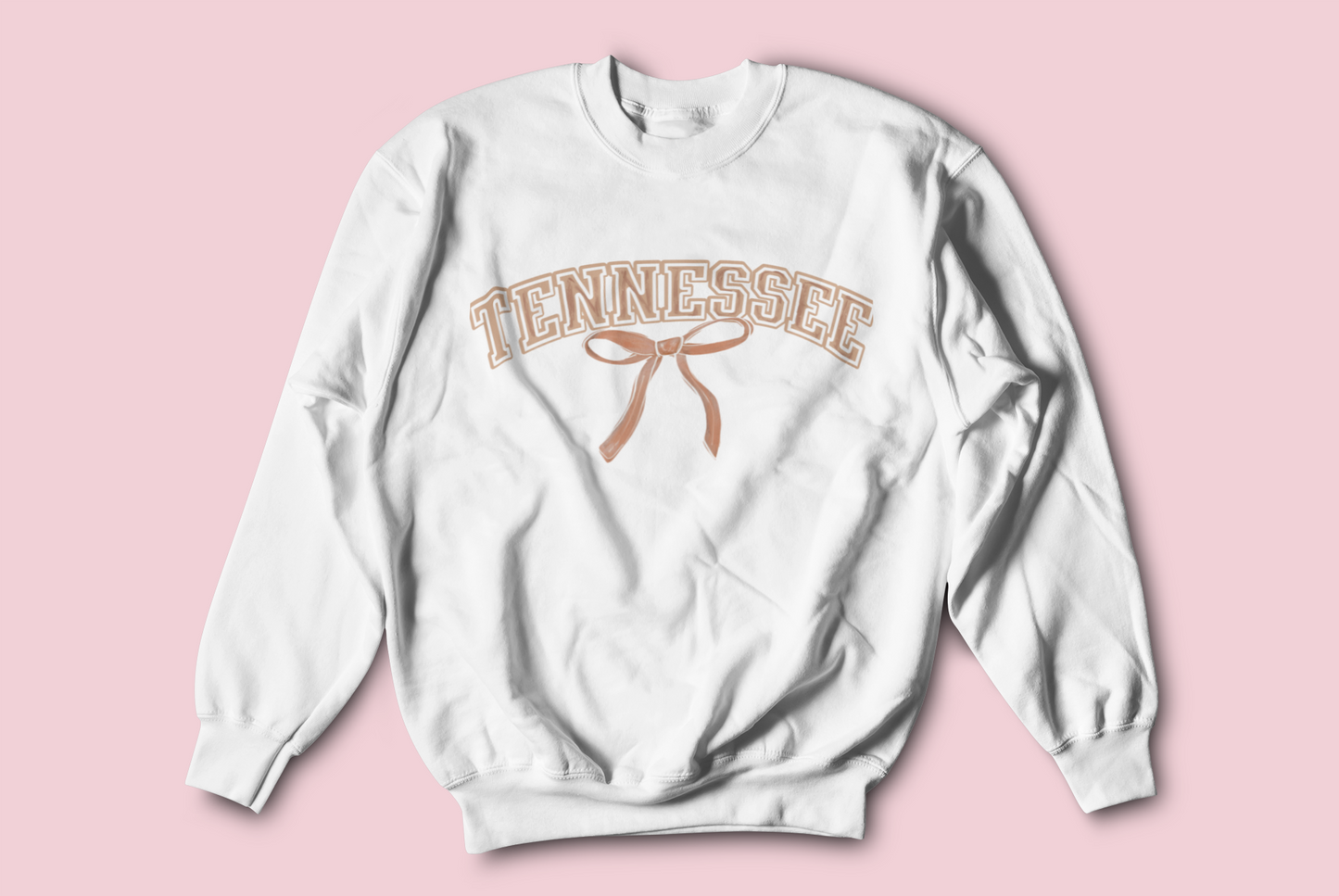 A white sweatshirt that say "Tennessee" in orange with a bow