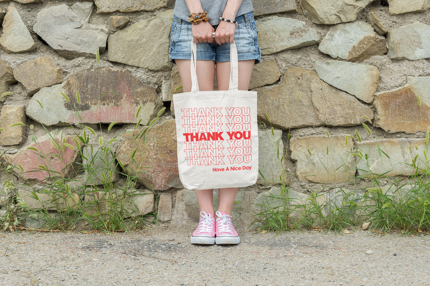 A girl holding a cream totes bag that say "Thank You, Have a Nice Day" written on it