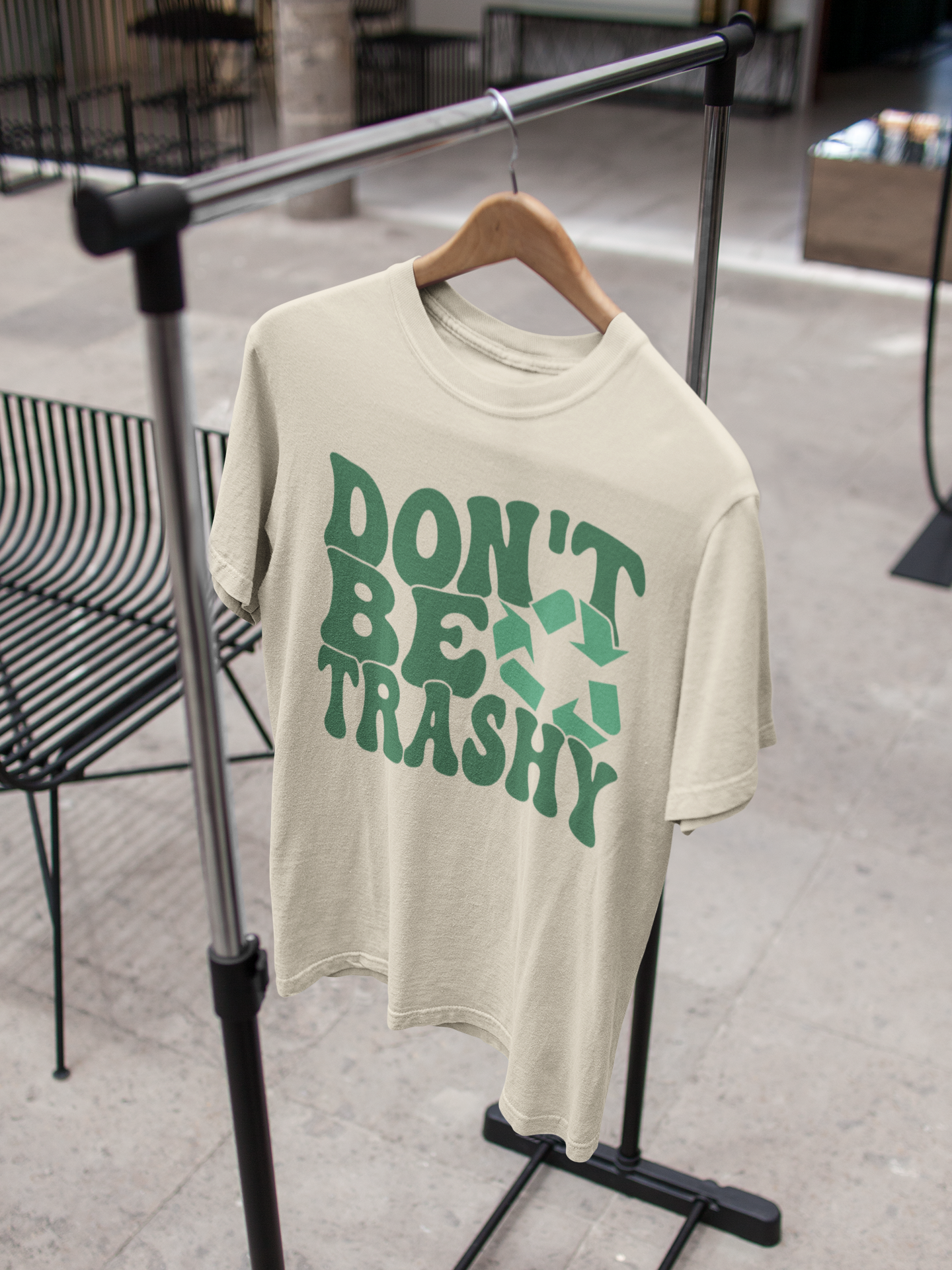 a beige t-shirt on a hanger that says "Don't be Trashy" on it with a recycle sign