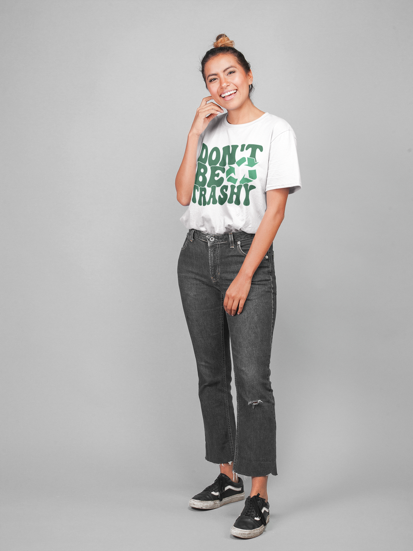 A girl smiling wearing a white t-shirt that says "Don't be Trashy" on it with a recycle sign