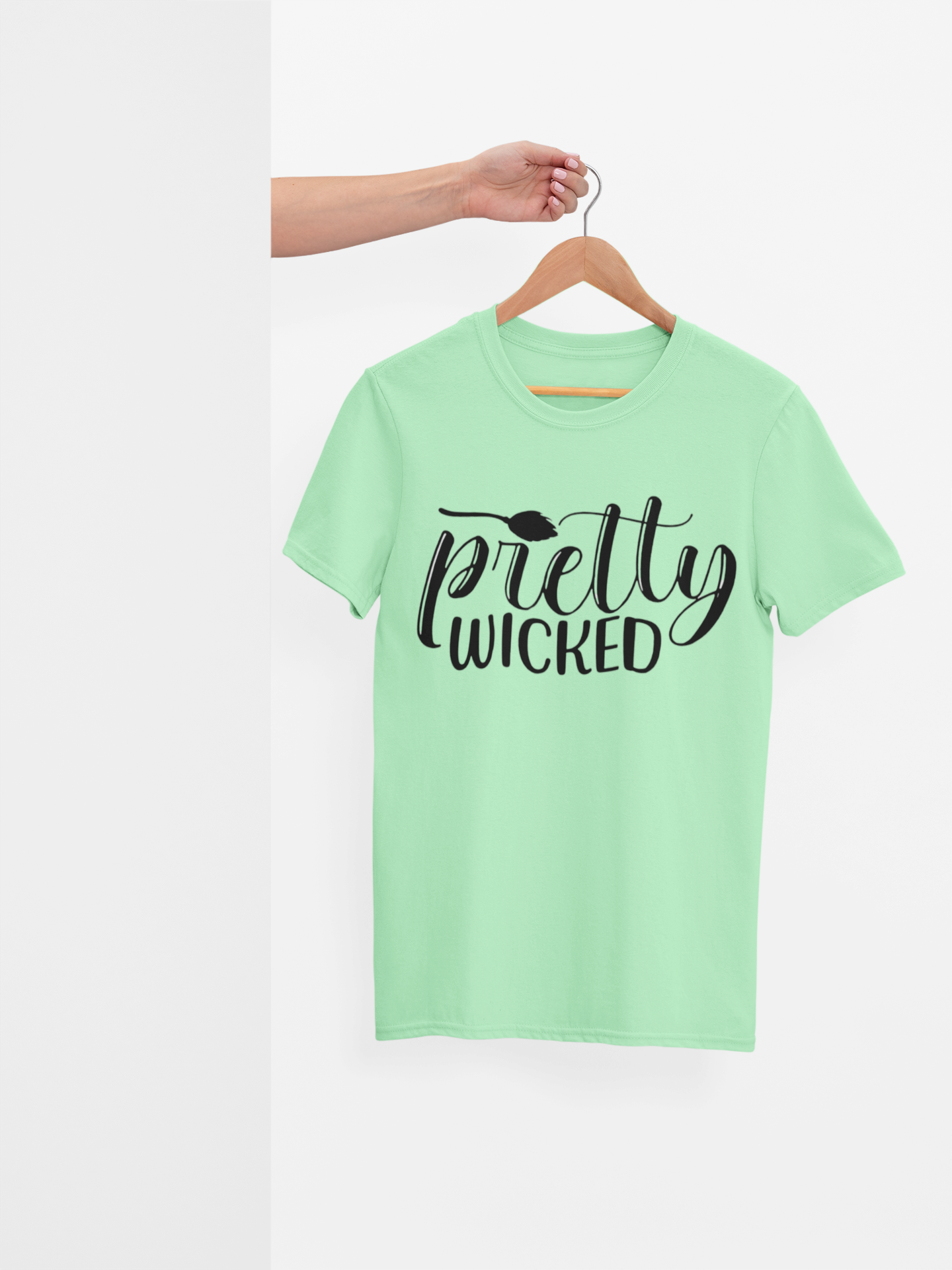 A person holding a "Pretty Wicked" T-Shirt on a hanger