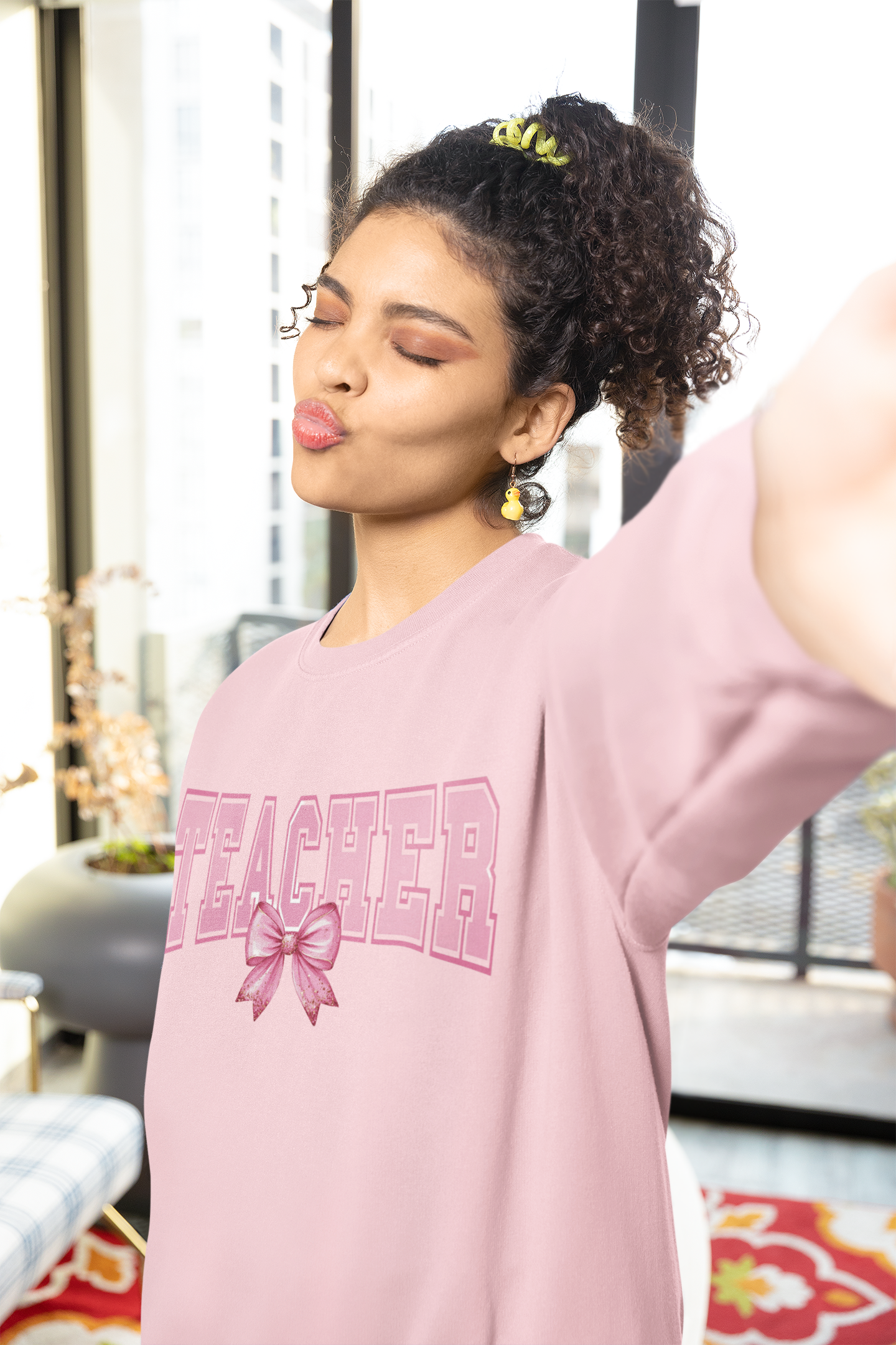 A girl wearing a pink sweatshirt that says Teacher